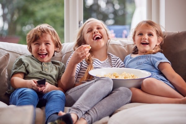 Des enfants souriants en regardant la télé