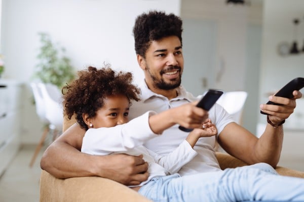 Une fille regardant la télé avec son père 