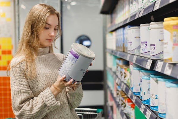 Une femme achète du lait au supermarché